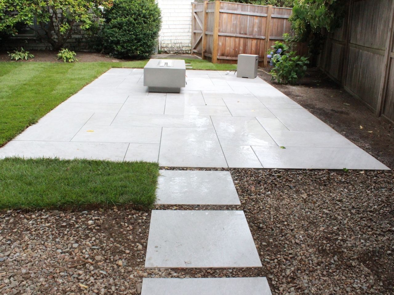 A square outdoor fireplace installed within a sitting area.