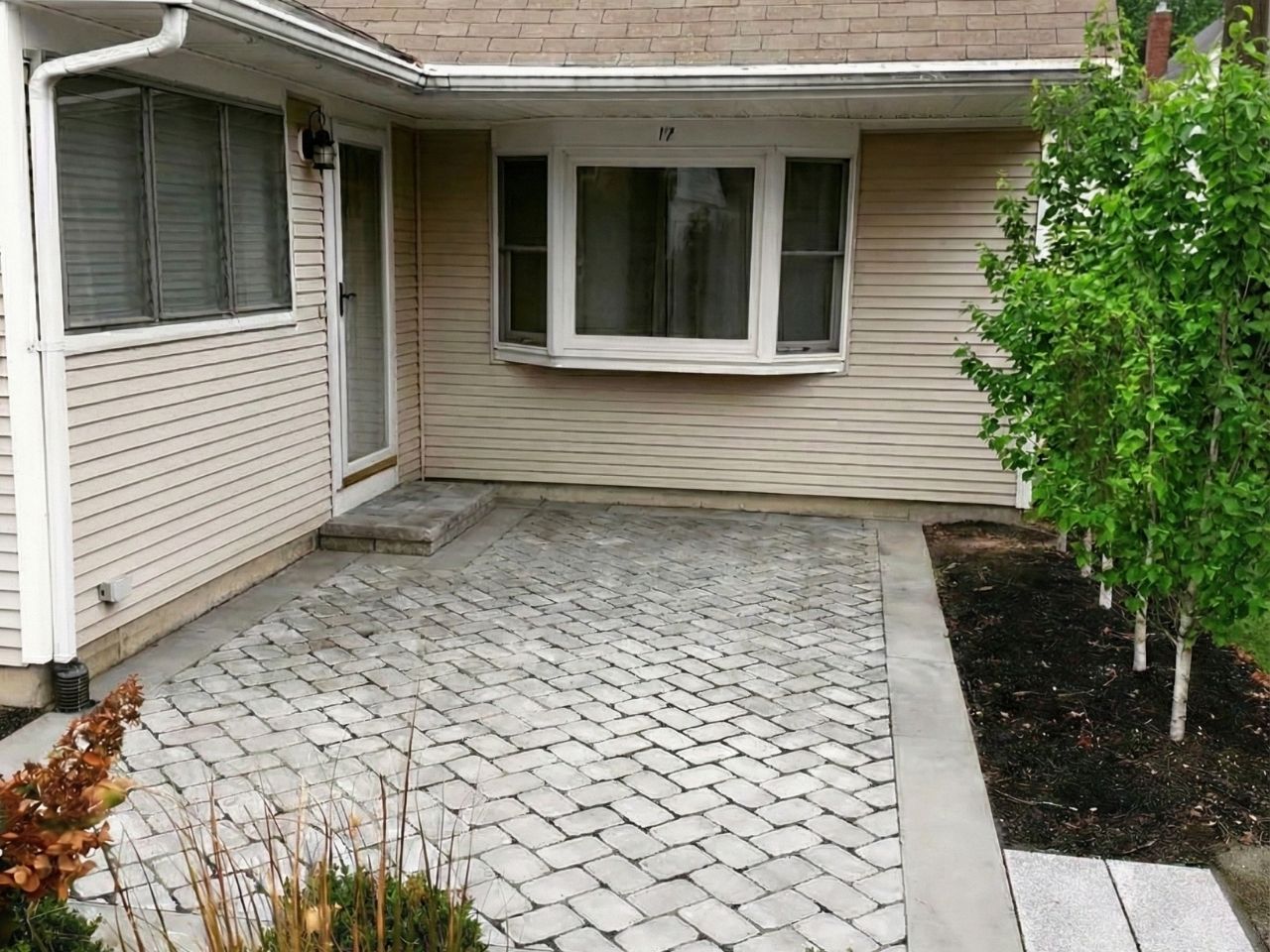 A square outdoor fireplace installed within a sitting area.