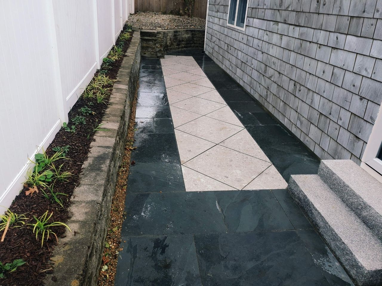 A square outdoor fireplace installed within a sitting area.