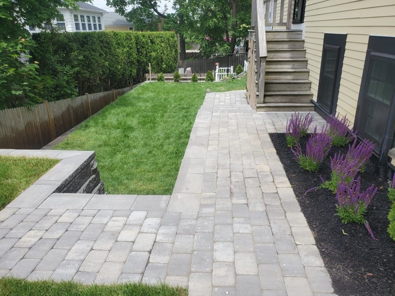 A square outdoor fireplace installed within a sitting area.